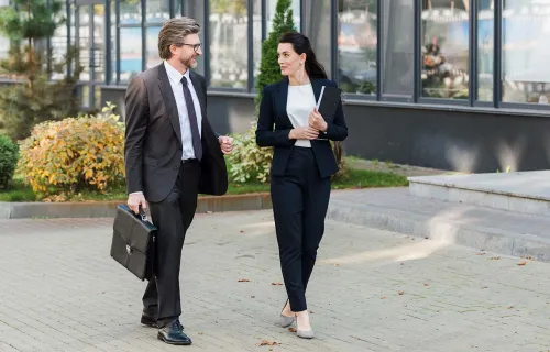Male and female professional walking into an office 